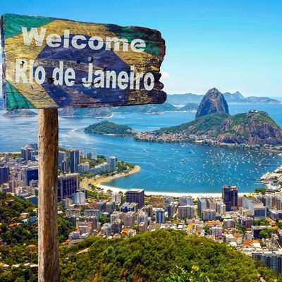 The iconic 'Rio' signboard in Rio de Janeiro, set against a backdrop of lush mountains and a clear blue sky