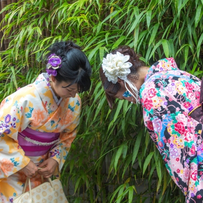 2 korean women bowing to each other while greeting