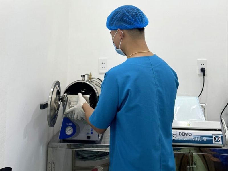 Assistant placing instruments in the autoclave for sterilization