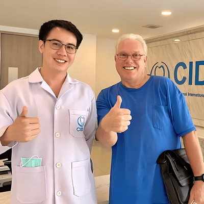 Mr. Neal, a satisfied patient, showing off his new dental veneers at CIDC Dental Clinic, smiling brightly with gratitude.