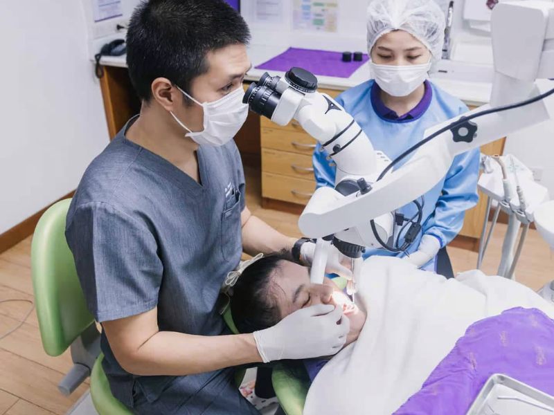 A dentist at Kitcha Dental Clinic performing a procedure with precision, wearing protective gear to ensure patient safety and hygiene.