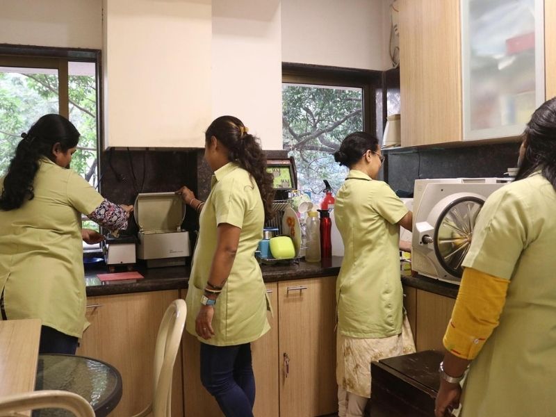 Dental staff in protective coats working in a lab where sterilization processes are being carried out