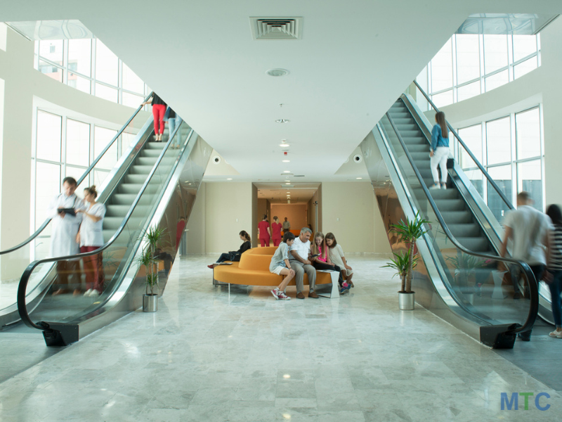 Spacious central hall with elevators on both sides and a cozy seating area in the center.