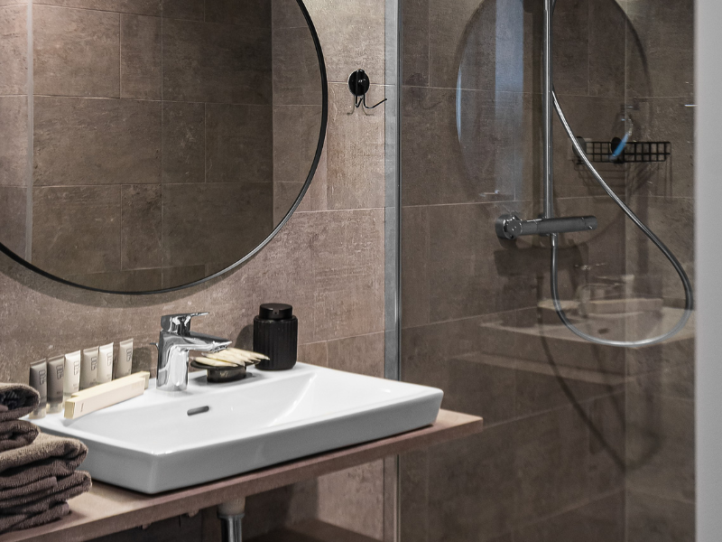 Minimalist wash basin with a mirror in a Lithuania recovery apartment, ensuring comfort and convenience for mommy makeover patients