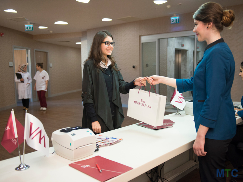 Receptionist at Turkey's top hospital giving a bag to patient. 