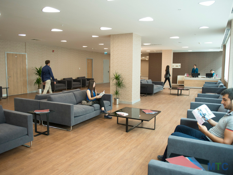 Modern waiting area featuring a sleek design, a stylish blue sofa, and a professional yet inviting ambiance