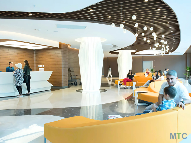 Clean and organized hospital consultation area with rows of comfortable chairs, bright lighting, and a calm atmosphere.