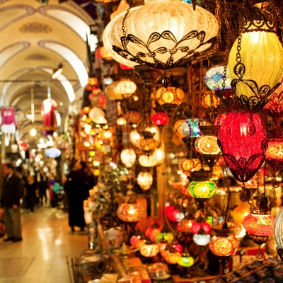 Grand Bazaar in Istanbul with a street market view, featuring numerous colorful lanterns hanging overhead, creating a vibrant atmosphere