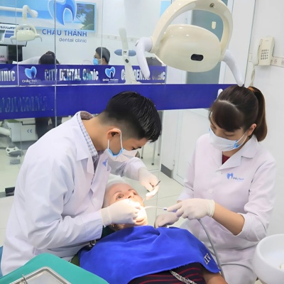 Two dentists performing a dental procedure on a patient at Australian Dental Clinic, Hanoi in a bright and clean environment.