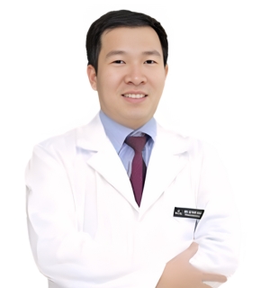 Dr.Vu Duc Nha in a white doctor's coat smiling at the camera with his arms folded in front